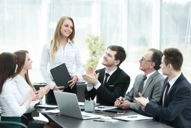 İş ekibi toplantıda konuşmacıyı alkışlıyor..