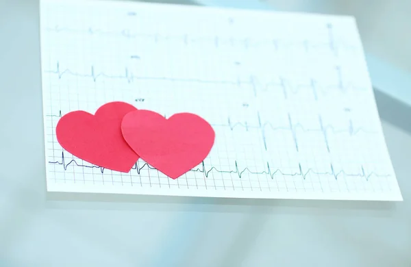 Cardiogram en twee rode papier hart op tafel — Stockfoto