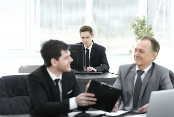 boss and employee discussing the document sitting at the Desk in the office.