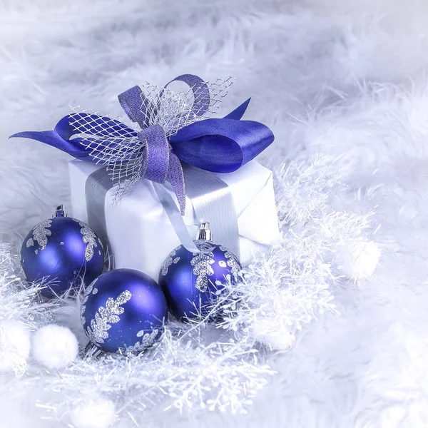 Cadeau de Noël et boules de Noël bleues sur un dos blanc festif — Photo