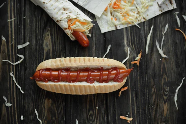 Rychlý food.hot dogs s omáčkou na dřevěné pozadí — Stock fotografie