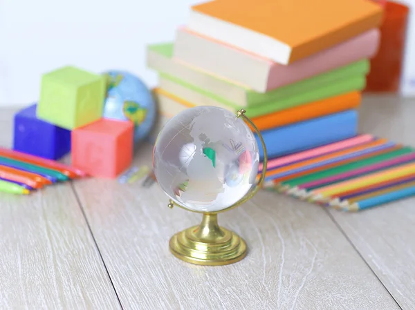 Üveg globe és iskolai kellékek, a fa background.photo — Stock Fotó