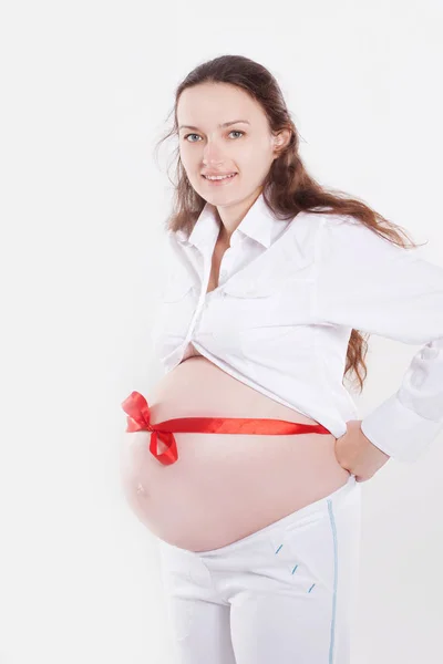 Mujer embarazada con cinta roja atada en el estómago — Foto de Stock