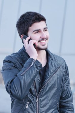 sokakta bir cep telefonunda konuşan genç adam