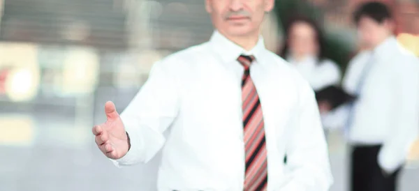 Sorridente empresário segurando a mão para cumprimentar — Fotografia de Stock