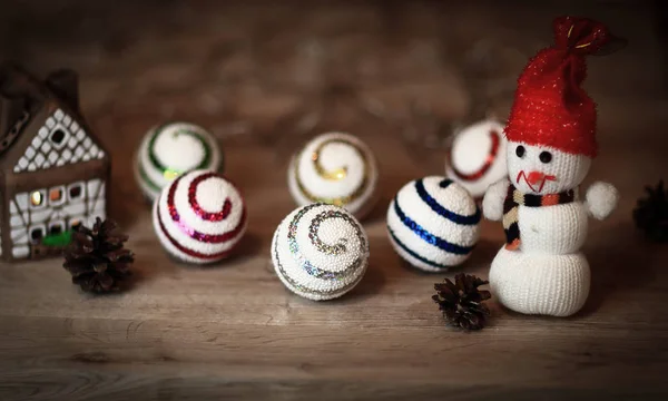Bolas de Navidad y un muñeco de nieve de juguete en la mesa de Navidad —  Fotos de Stock