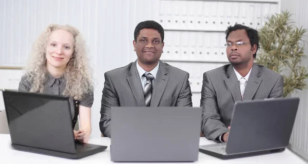 A nyitott laptopok előtt ülő alkalmazottak. fehér alapon izolálva — Stock Fotó