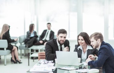 Başarılı iş ekibi dizüstü bilgisayarda çalışıyor ve güncel mali raporu hazırlıyor.