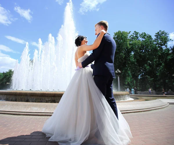Marié amoureux et la mariée contre une fontaine . — Photo