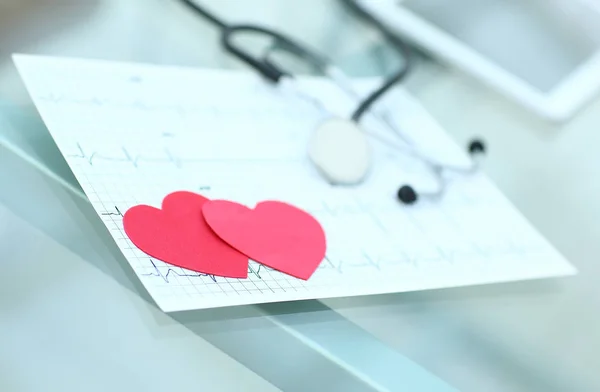 Stethoscoop, cardiogram en twee rode papier hart op tafel. — Stockfoto