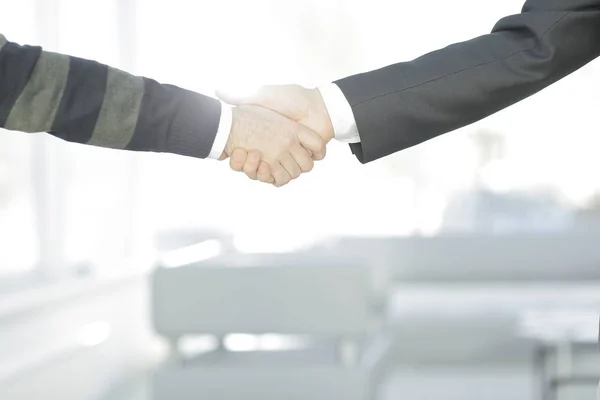 Cerrar up.businessmen estrechando la mano en borrosa oficina de fondo . — Foto de Stock