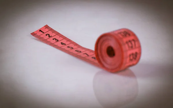 Складений червоний сантиметр ізольований на сірому фоні — стокове фото
