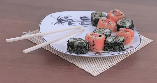 Close-up of sushi and chopsticks on a white plate — Stock Photo, Image