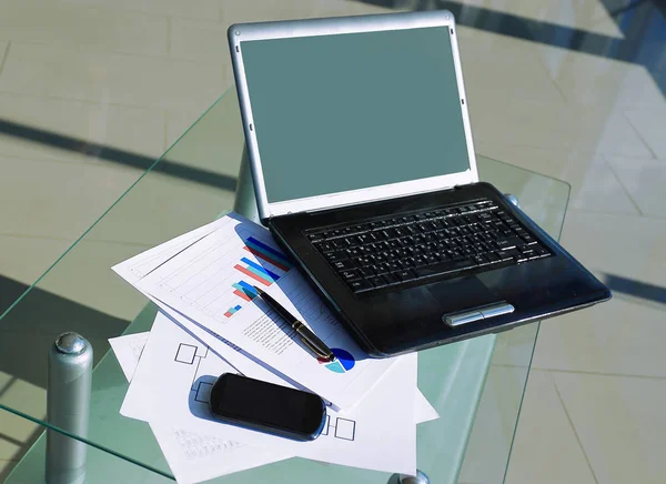 Открытый ноутбук и мобильный телефон на рабочем столе — стоковое фото