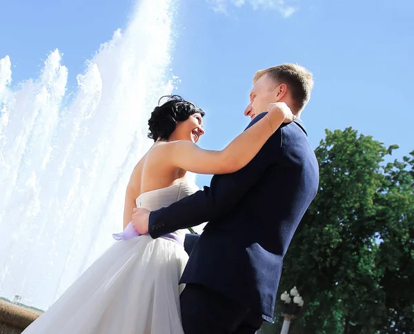 Marié amoureux et la mariée contre une fontaine . — Photo