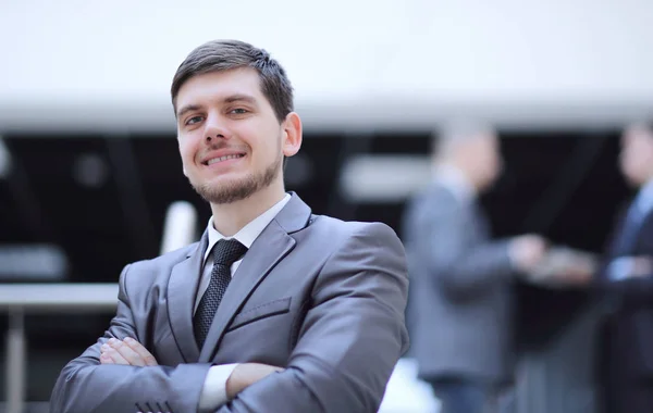 Портрет привлекательного бизнесмена на размытом офисном фоне — стоковое фото