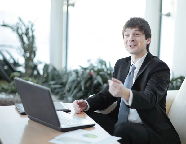 Homem de negócios conversando com colega sentado em sua mesa — Fotografia de Stock