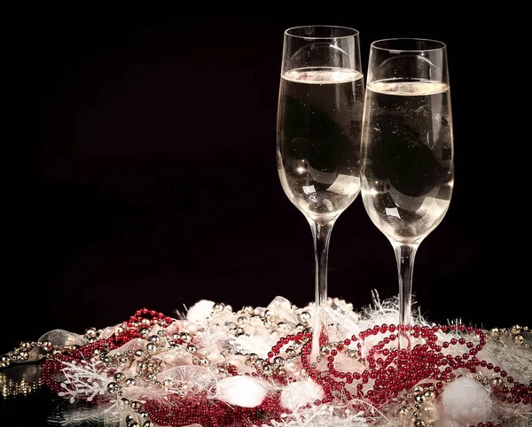 Divertente pupazzo di neve giocattolo e due bicchieri di champagne su un backgro nero — Foto Stock