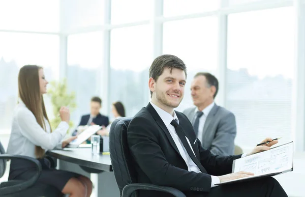 Hombre de negocios en la oficina con su equipo de negocios trabajando detrás — Foto de Stock