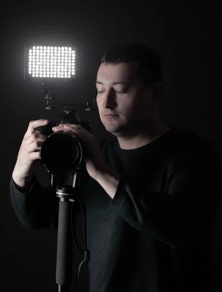 Fotógrafo profissional com câmera em tripod.isolated em fundo preto — Fotografia de Stock