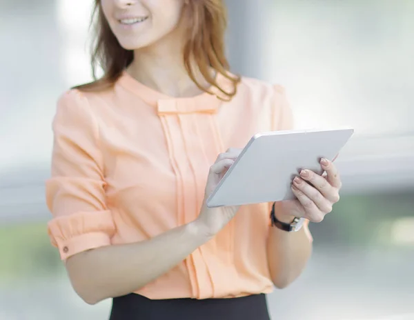 Femme d'affaires confiante avec tablette numérique sur fond de bureau flou . — Photo