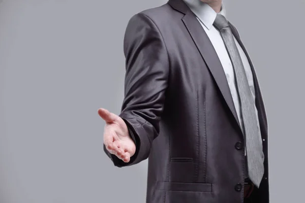 Close up. the businessman extends his hand for greeting .isolated on grey background — Stock Photo, Image