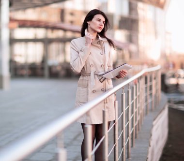 Bir ofis binasının yanında duran bir dijital tablet üzerinde çalışan Modern iş kadın