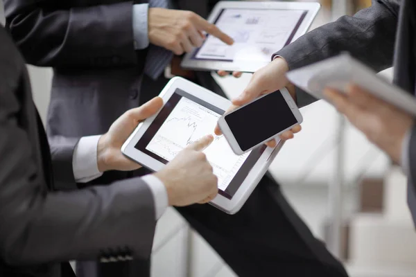 Empresarios en reunión presentando cartas en smartphone, tableta —  Fotos de Stock