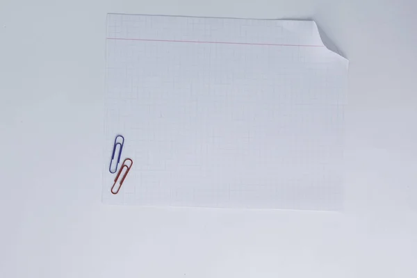 Cerrar. Una hoja de cuaderno y clip de papel. Foto con spa de copia —  Fotos de Stock