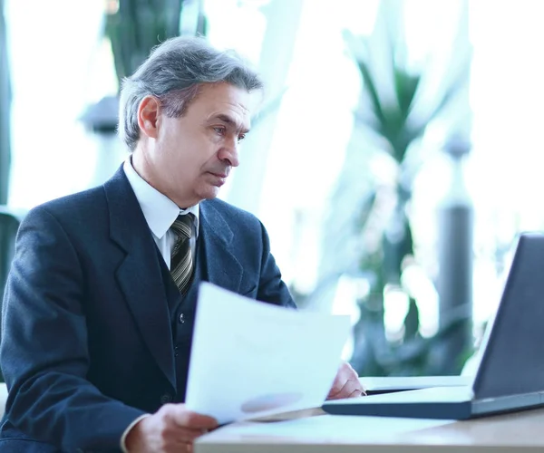 Affärsman som arbetar med affärsdokument som sitter vid sitt skrivbord. — Stockfoto