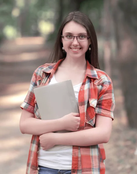Park arka plan üzerinde bir pano ile gülümseyen öğrenci kız — Stok fotoğraf