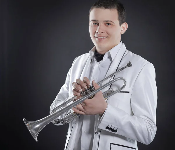 黒の背景に trumpet.isolated と白いスーツの若い男 — ストック写真