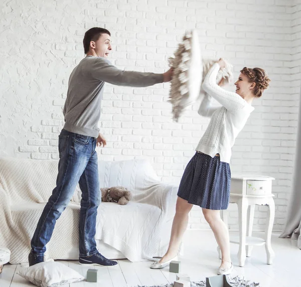 Familia feliz jugando con un perro mascota en la amplia sala de estar — Foto de Stock