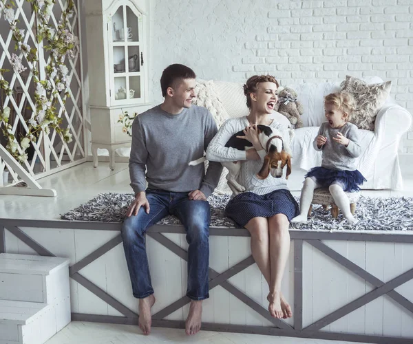 Retrato de uma família feliz e seu animal de estimação em uma sala de estar aconchegante — Fotografia de Stock