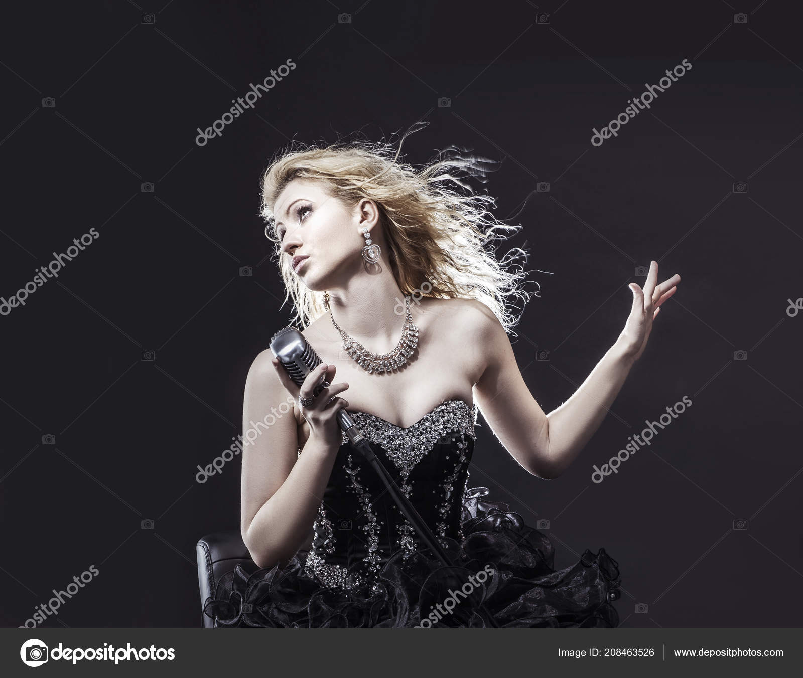 Beautiful Blonde Woman Singer In A Black Dress Holding A