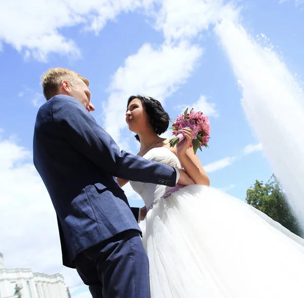 Närbild av en kärleksfull brud och brudgum på bakgrunden av fontänen — Stockfoto