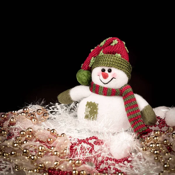 Divertente pupazzo di neve giocattolo e decorazioni natalizie su sfondo nero — Foto Stock