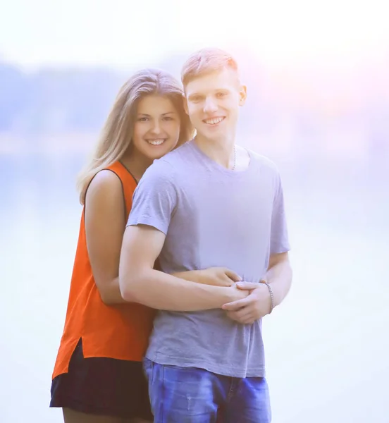 Mädchen umarmt ihren Freund, während sie am See steht — Stockfoto