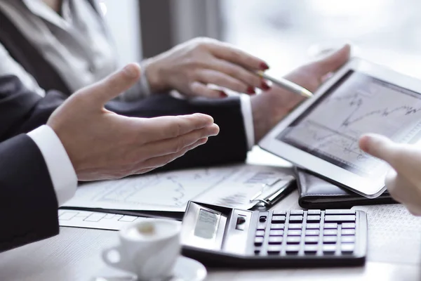 Zespołu Business używa cyfrowego tabletu, aby sprawdzić dane finansowe. — Zdjęcie stockowe