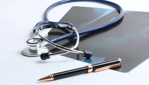Stetoscopio, radiografia e penna sul tavolo . — Foto Stock