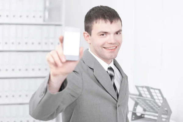 Uomo che mostra lo schermo dello smartphone, mentre in piedi in ufficio . — Foto Stock