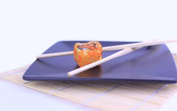 Gros plan des sushis et des baguettes sur une assiette noire — Photo
