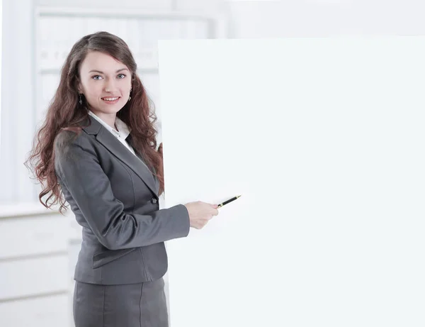Mulher de negócios com um lápis apontando para um cartaz em branco . — Fotografia de Stock