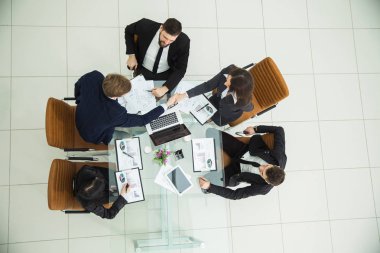  Yeni mali anlaşmasını bir tartışmanın ardından el sıkışan iş ortakları