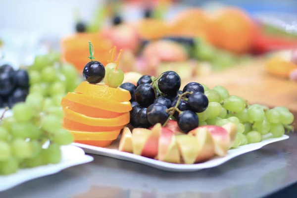 Close up.plates with grapes and fruits on blurred background — Stock Photo, Image