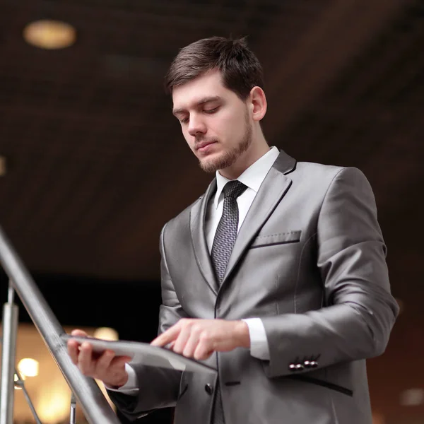 Hombre de negocios guapo de pie en los pasos utilizando tableta en el edificio de oficinas —  Fotos de Stock