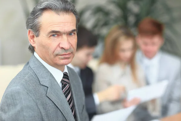 Porträtt av säker affärsman på suddig office bakgrund — Stockfoto