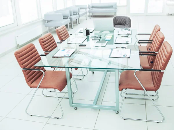 Mesa para negociações com os gráficos financeiros preparados e equipamentos de escritório na sala de conferências antes de reuniões de negócios . — Fotografia de Stock