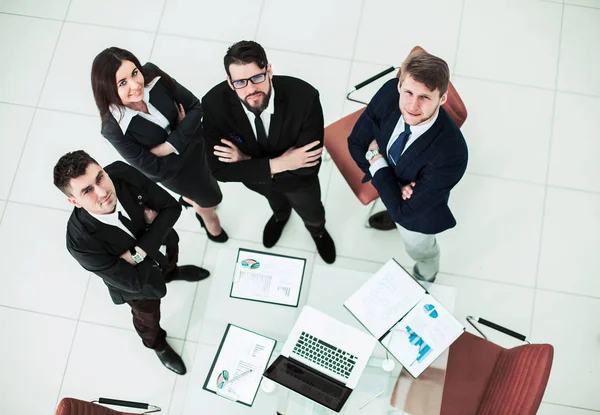 Úspěšný obchodní tým stojí vedle sebe poblíž pracoviště v kanceláři — Stock fotografie