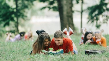arkadaşlar sınav için hazırlanıyor öğrencilerin çim üzerinde yalan